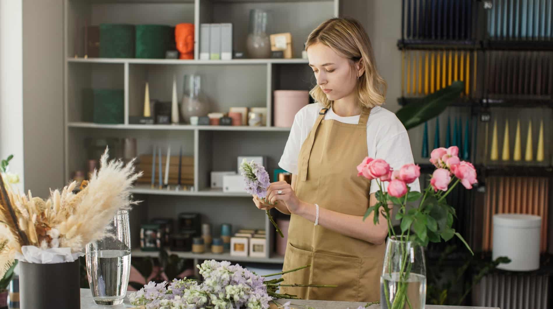 A woman arranges flowers in her florist shop.