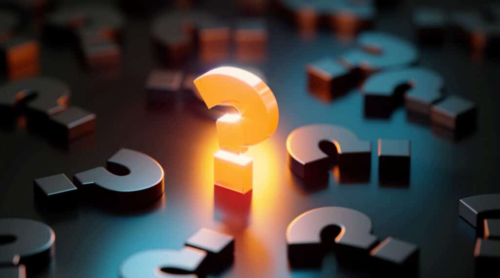 Yellow question mark glowing amid black question marks on black background.
